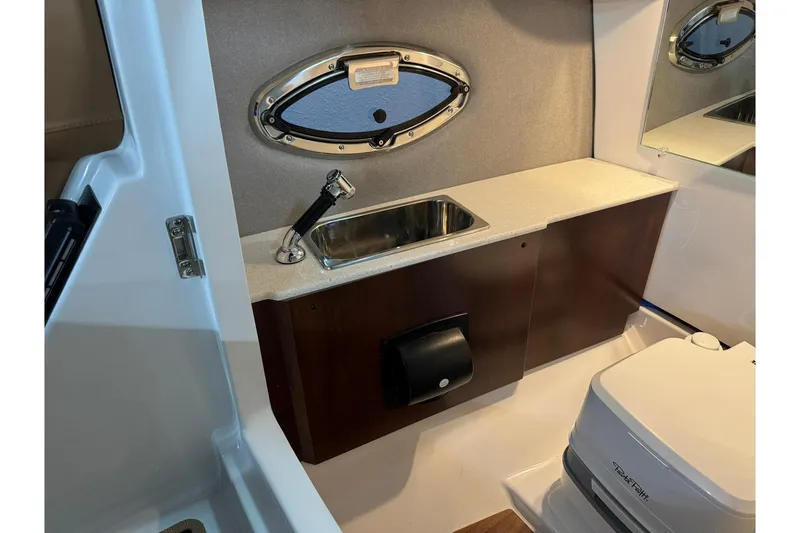 Slide: The Image of 2026 Chaparral SSX 6 boat interior with sink, mirror, and compact toilet. - 34