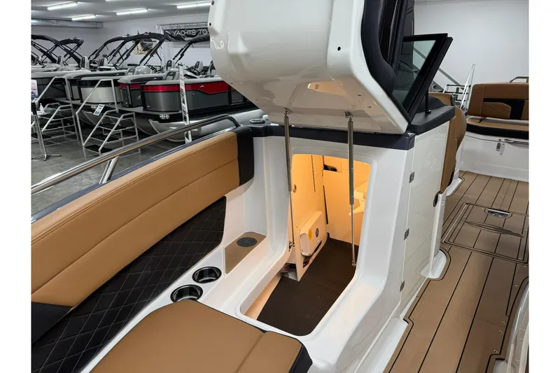 Slide: The Image of 2026 Chaparral SSX 6 boat interior with tan seating and open storage compartment. - 44