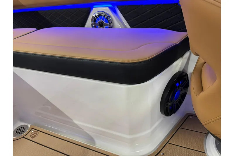 Slide: The Image of 2026 Chaparral SSX 6 boat interior with tan seating, blue LED lighting, and speaker system. - 46