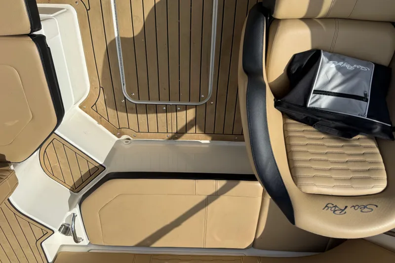 Slide: The Image of 2021 Sea Ray 19 SPX OB boat interior with tan seating and wood flooring. - 17