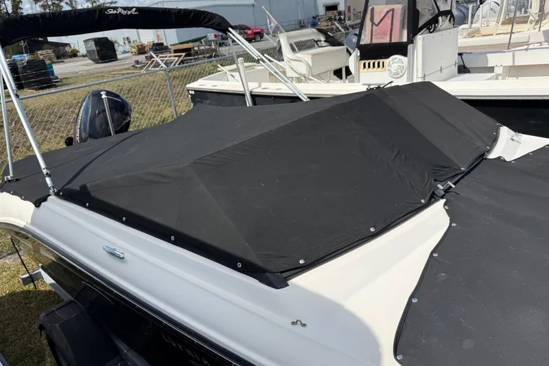 Slide: The Image of 2021 Sea Ray 19 SPX OB boat with black cover in a marina setting. - 22