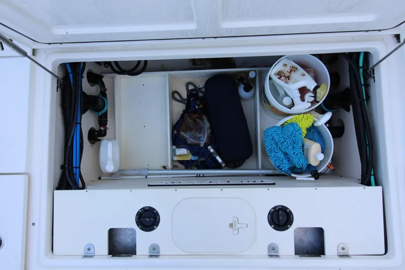Slide: The Image of Storage compartment of a 2015 Boston Whaler 320 Outrage, organized with cleaning supplies. - 17