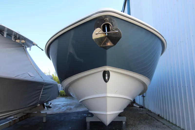 Slide: The Image of 2015 Boston Whaler 320 Outrage boat, front view, docked beside a covered vessel. - 36