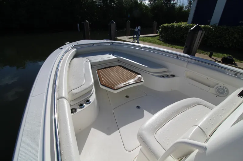 Slide: The Image of 2015 Boston Whaler 320 Outrage boat interior with seating and wooden table. - 4