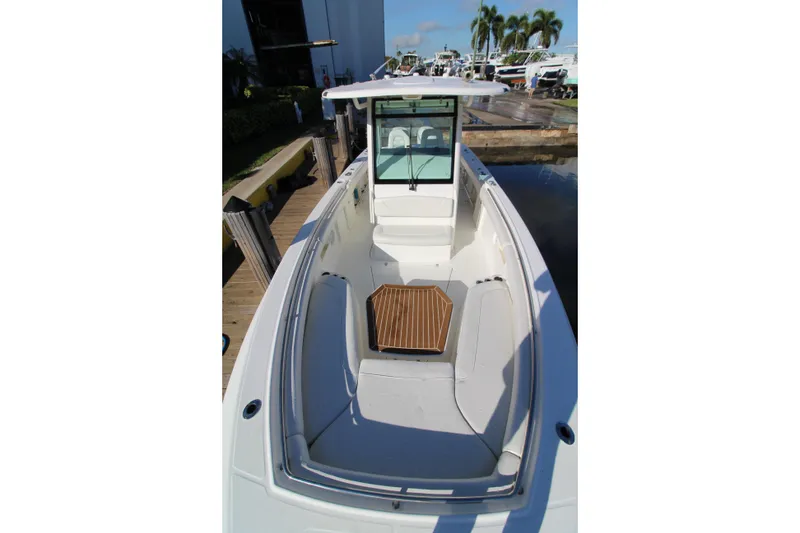 Slide: The Image of 2015 Boston Whaler 320 Outrage boat docked, showcasing spacious seating and sleek design. - 5