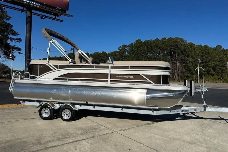 The Image of 2026 Bennington 22 S Quad Bench pontoon boat on trailer, parked outdoors. - 1