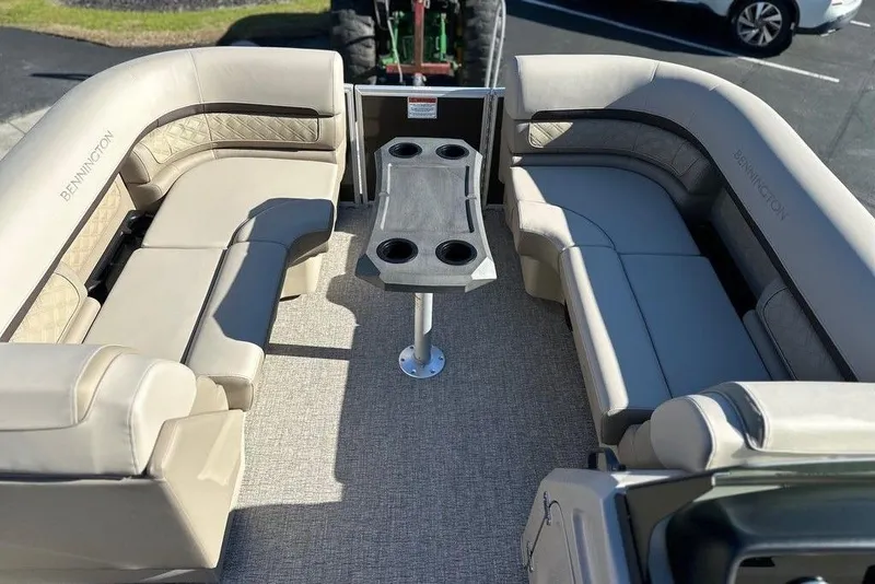 Slide: The Image of 2026 Bennington 22 S Quad Bench interior with plush seating and central table. - 7