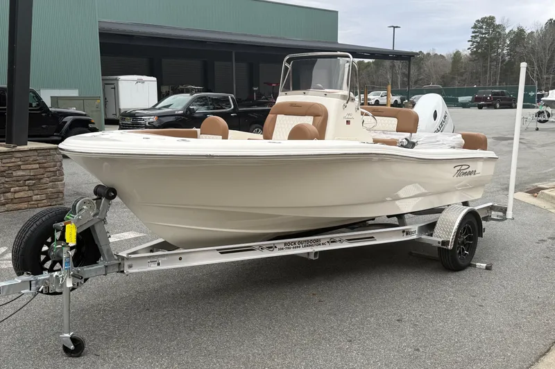 Slide: The Image of 2026 Pioneer 180 Islander boat on trailer, parked outdoors near a building. - 1