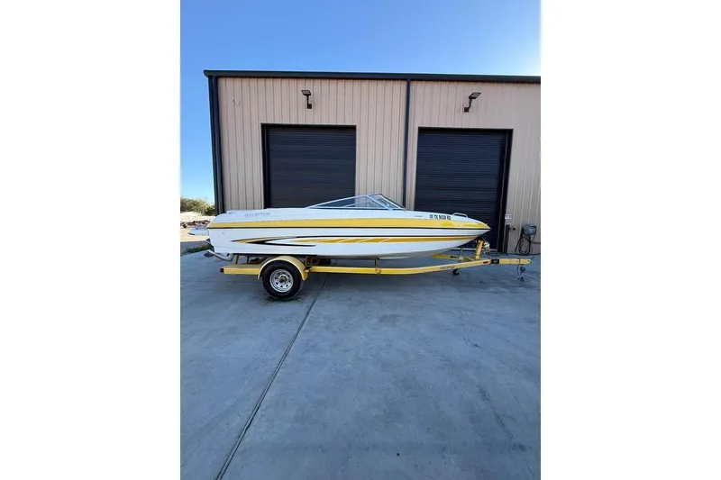 Slide: The Image of 2008 Glastron GX 205 boat on trailer, parked outside a garage. - 11