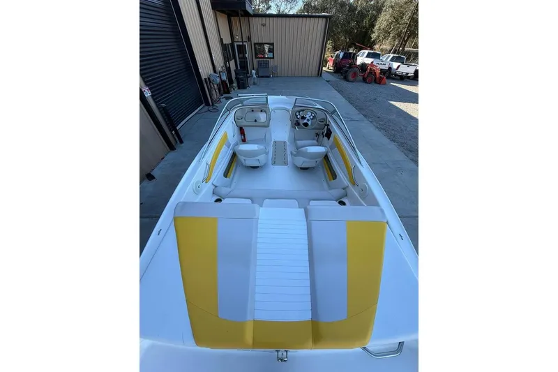 Slide: The Image of 2008 Glastron GX 205 boat interior with yellow and white seating, parked outdoors. - 3