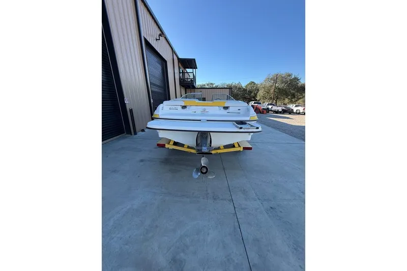 Slide: The Image of 2008 Glastron GX 205 boat on trailer, parked outside a warehouse. - 5