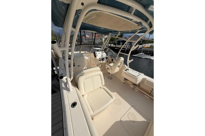 Slide: The Image of 2019 Grady-White Freedom 235 boat interior with seating and helm, docked by the water. - 2