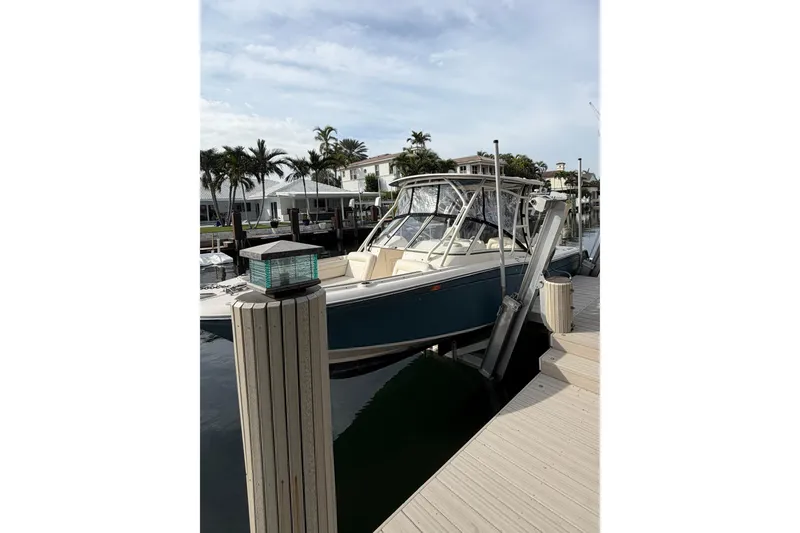 Slide: The Image of 2019 Grady-White Freedom 235 boat docked at marina with palm trees in background. - 6