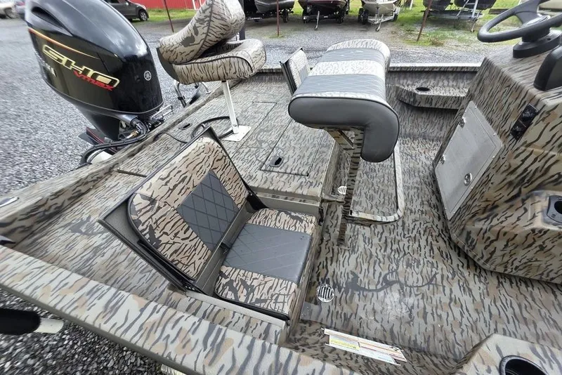 Slide: The Image of 2026 Xpress H20B Bay boat interior with camo seats and Yamaha outboard motor. - 5