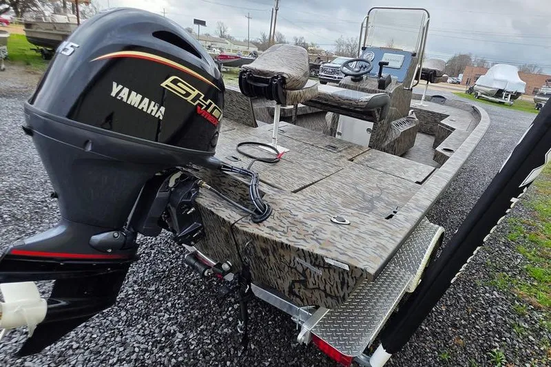 Slide: The Image of 2026 Xpress H20B Bay boat with Yamaha engine, parked on gravel. - 9