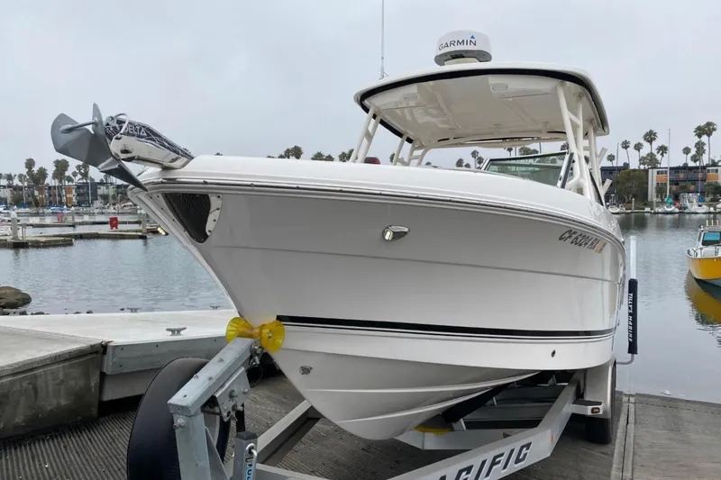 Slide: The Image of 2017 Robalo R247 Dual Console boat on trailer at marina dock. - 3