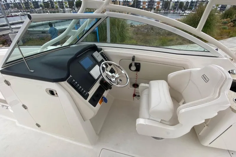 Slide: The Image of 2017 Robalo R247 Dual Console boat interior with steering wheel and captain's seat. - 9