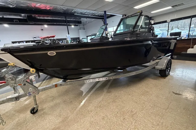 Slide: The Image of 2026 Lund 1700 Explorer Sport boat on display in a showroom. - 1