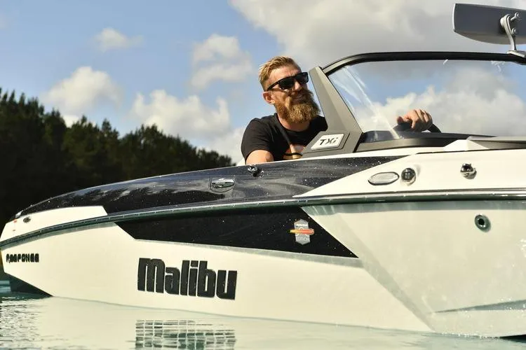 Slide: The Image of 2017 Malibu Response TXi Open Bow boat on water with driver, sunny day. - 9