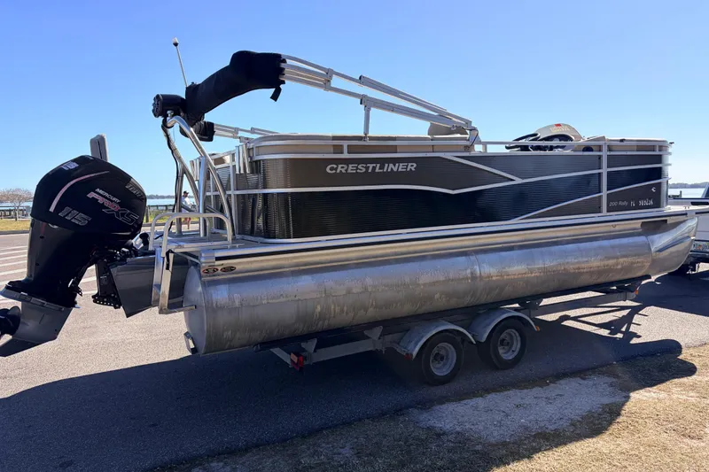 Slide: The Image of 2019 Crestliner 200 Rally CS pontoon boat on trailer, featuring Mercury engine. - 13