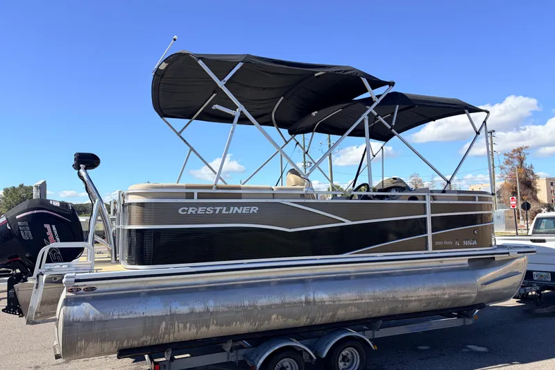 Slide: The Image of 2019 Crestliner 200 Rally CS pontoon boat on trailer under clear blue sky. - 3