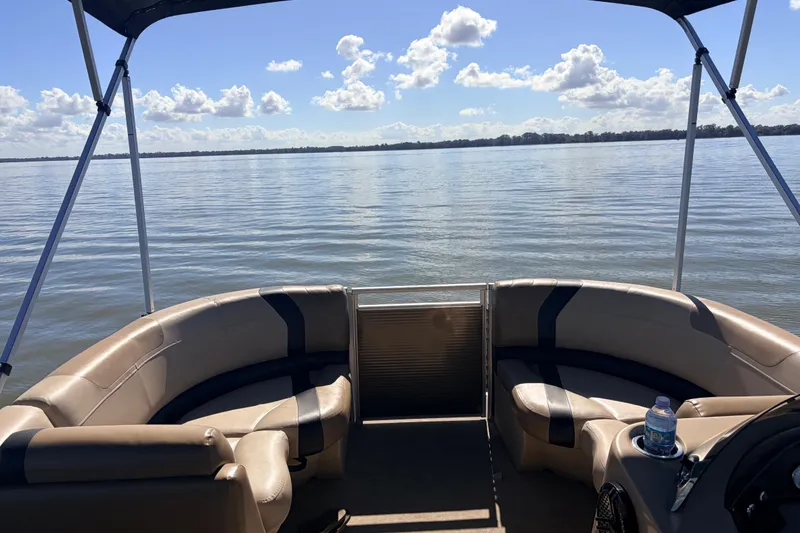 Slide: The Image of 2019 Crestliner 200 Rally CS pontoon boat on a calm lake under a sunny sky. - 4