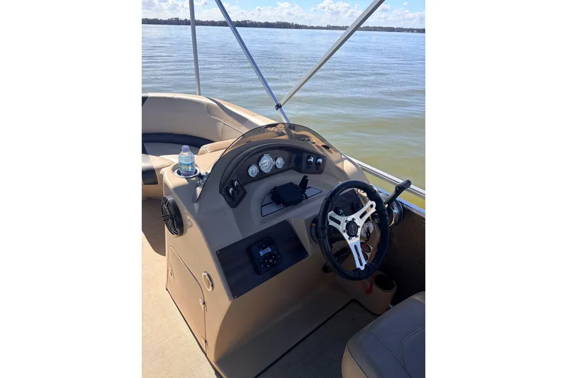 Slide: The Image of 2019 Crestliner 200 Rally CS boat dashboard with steering wheel and controls on a calm lake. - 5