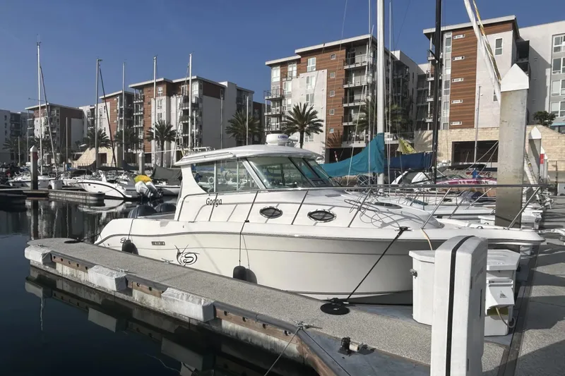 The Image of 2009 Seaswirl Striper 2901 Walkaround O/B docked at a marina with modern buildings. - 0