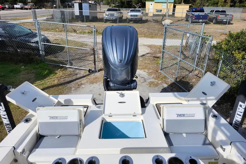 Slide: The Image of 2022 Pathfinder 2400 TRS boat with open storage compartments and outboard motor. - 11