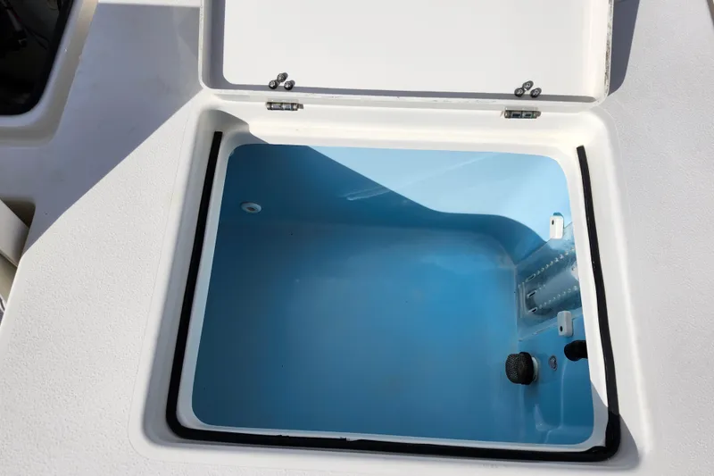 Slide: The Image of Open storage compartment on 2022 Pathfinder 2400 TRS boat, featuring a blue interior. - 14