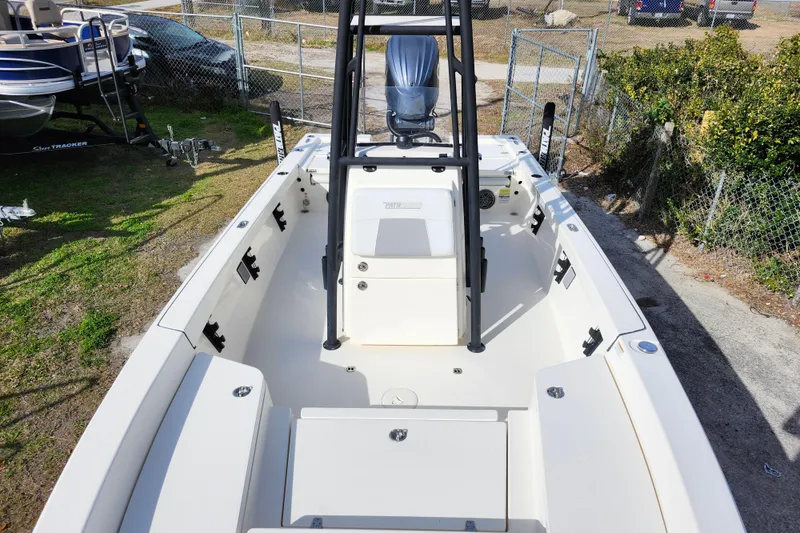 Slide: The Image of 2022 Pathfinder 2400 TRS boat interior with seating and console, parked outdoors. - 29