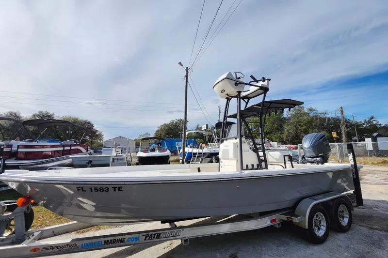 Slide: The Image of 2022 Pathfinder 2400 TRS boat on trailer, parked outdoors under a clear sky. - 36