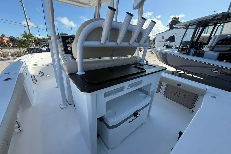 Slide: The Image of 2026 Crevalle 24 HCO boat interior with seating, rod holders, and cooler storage. - 11