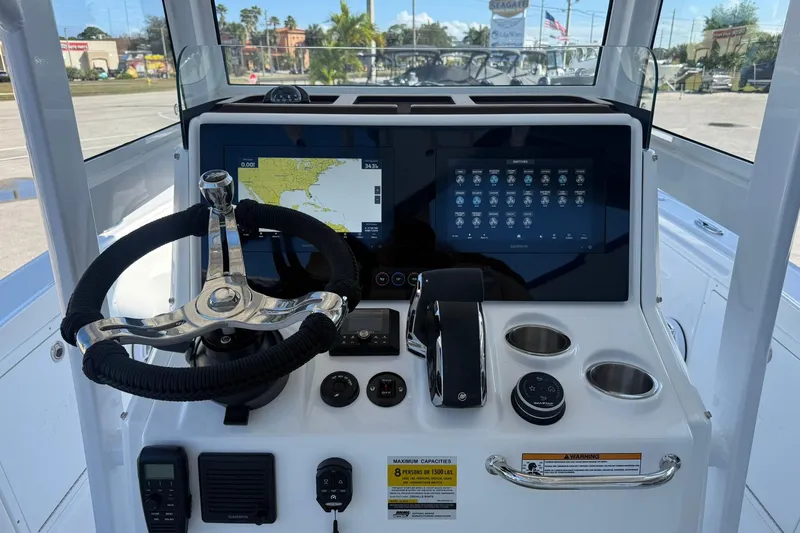 Slide: The Image of 2026 Crevalle 24 HCO boat dashboard with steering wheel, navigation screens, and controls. - 14