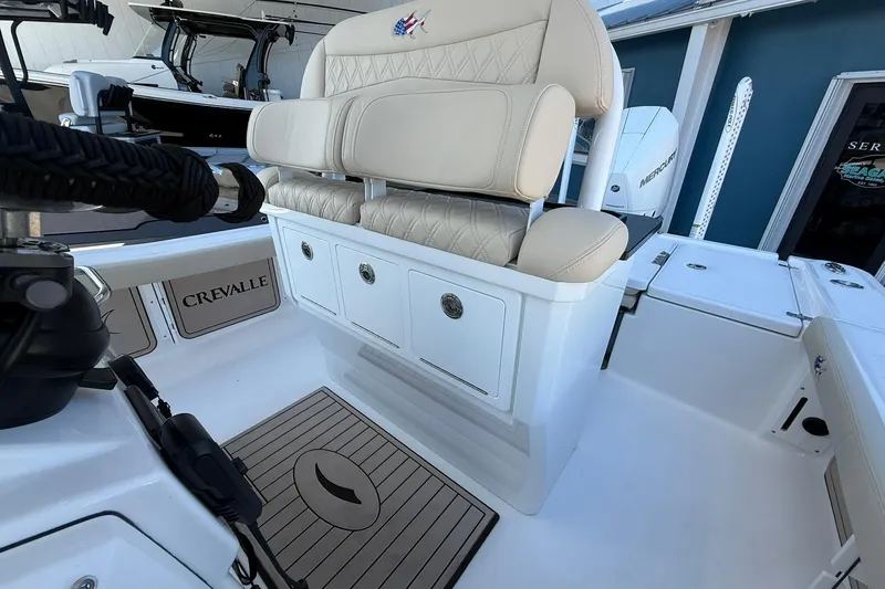 Slide: The Image of 2026 Crevalle 24 HCO boat interior with cushioned seating and storage compartments. - 16