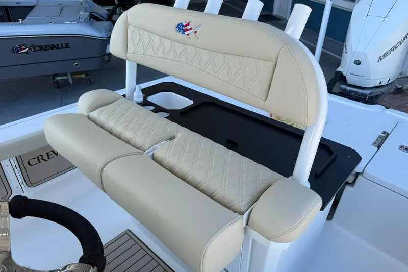Slide: The Image of 2026 Crevalle 24 HCO boat with beige cushioned seating and rod holders. - 17