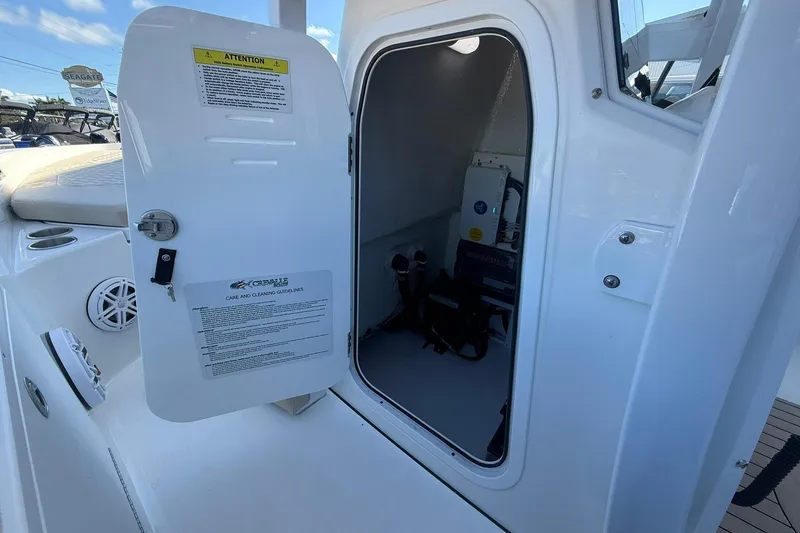 Slide: The Image of 2026 Crevalle 24 HCO boat storage compartment with open door, showing interior details. - 20