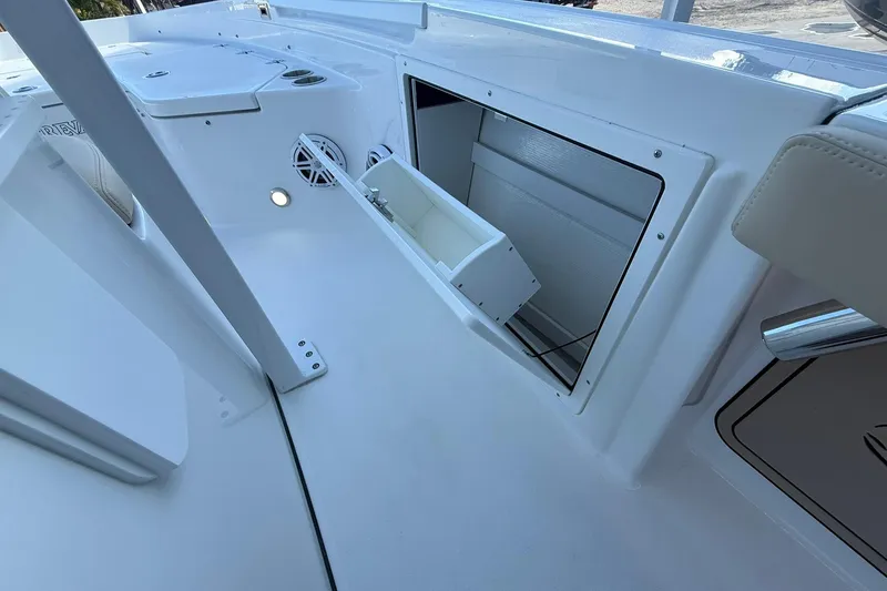 Slide: The Image of 2026 Crevalle 24 HCO boat interior with open storage compartment and speakers. - 24