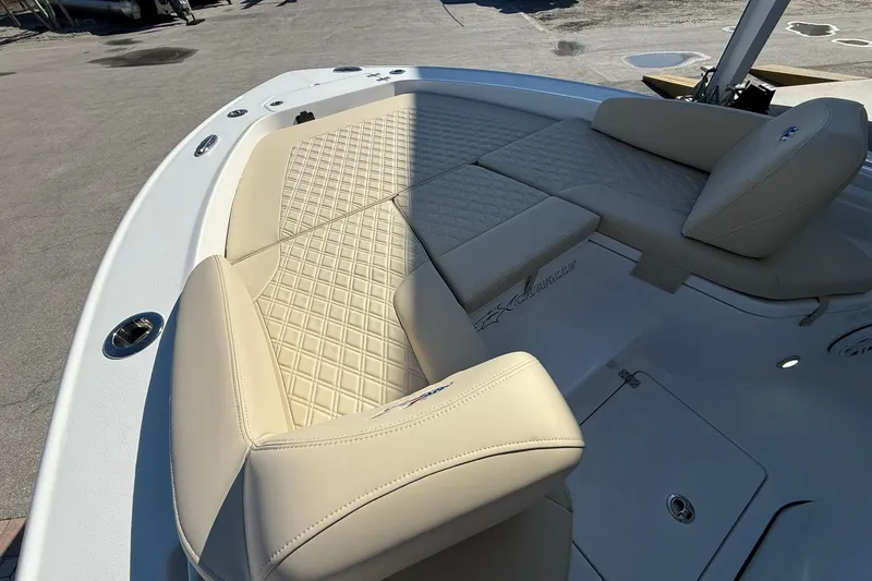 Slide: The Image of 2026 Crevalle 24 HCO boat with beige cushioned seating and diamond stitching. - 28