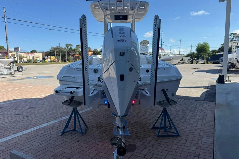 Slide: The Image of 2026 Crevalle 24 HCO boat with powerful outboard motor on display in a sunny marina. - 3