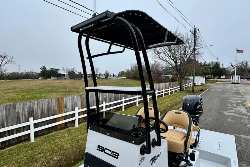 Slide: The Image of 2026 SCB R24 boat with T-top and Yamaha engine on a road near a grassy field. - 17
