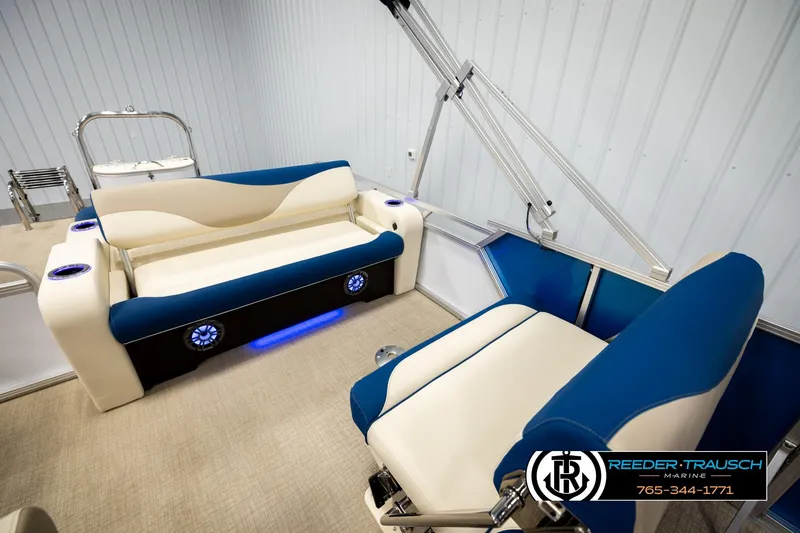 Slide: The Image of 2026 Avalon LSZ ENT boat interior with blue and white seating, cup holders, and LED lighting. - 22