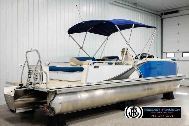 Slide: The Image of 2026 Avalon LSZ ENT pontoon boat with blue canopy in showroom. - 6