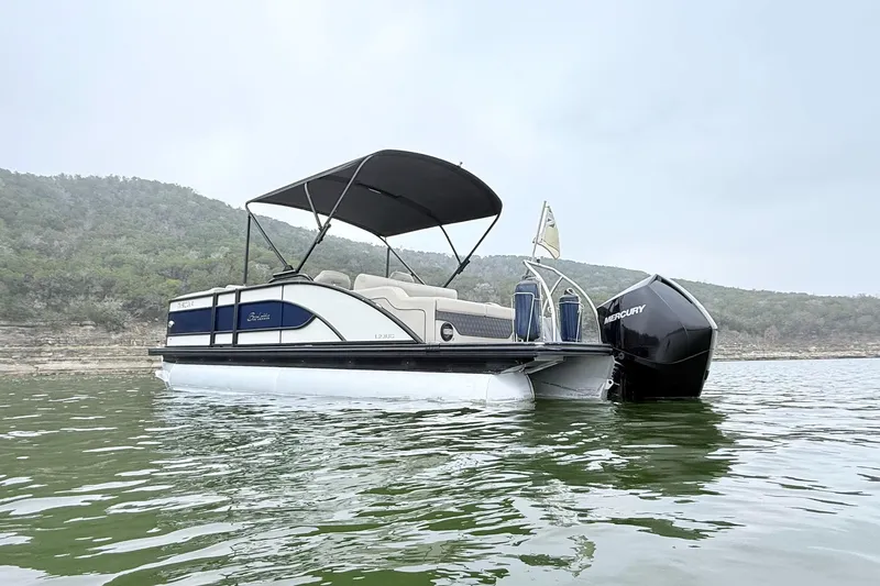 Slide: The Image of 2020 Barletta L23UC pontoon boat on a calm lake with scenic background. - 3