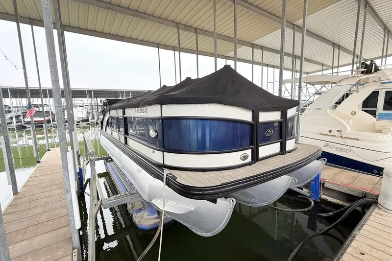 Slide: The Image of 2020 Barletta L23UC pontoon boat docked under a covered marina. - 9
