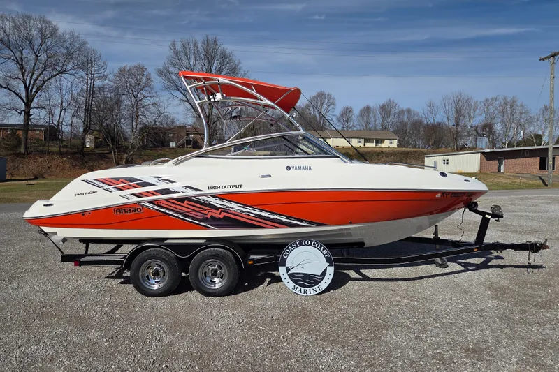 The Image of 2008 Yamaha Boats AR230 HO on trailer, vibrant red and white design, parked outdoors. - 0