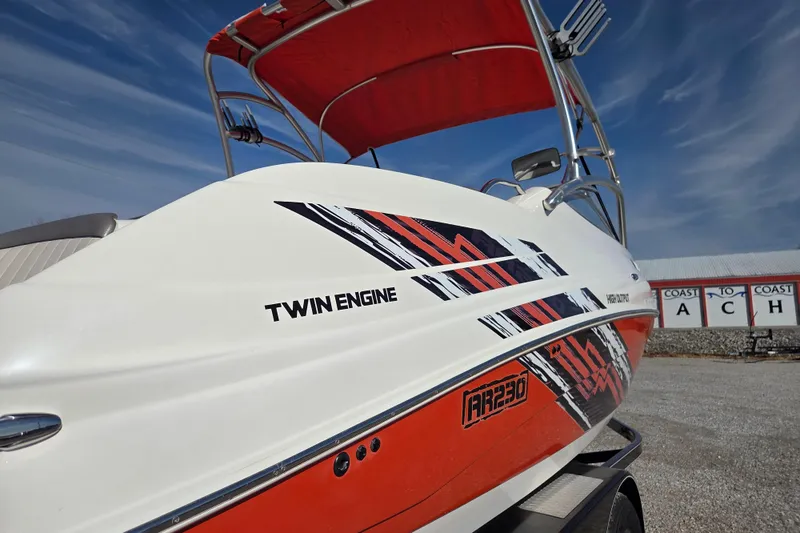 Slide: The Image of 2008 Yamaha Boats AR230 HO with twin engines and vibrant graphics, parked outdoors. - 4