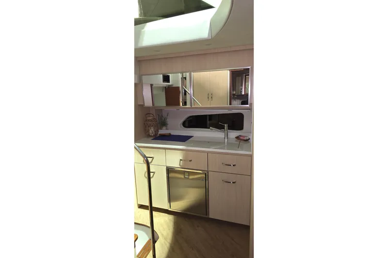 Slide: The Image of Interior of 2024 Regal 42 Fly yacht with American flag pillow on white seating. - 64