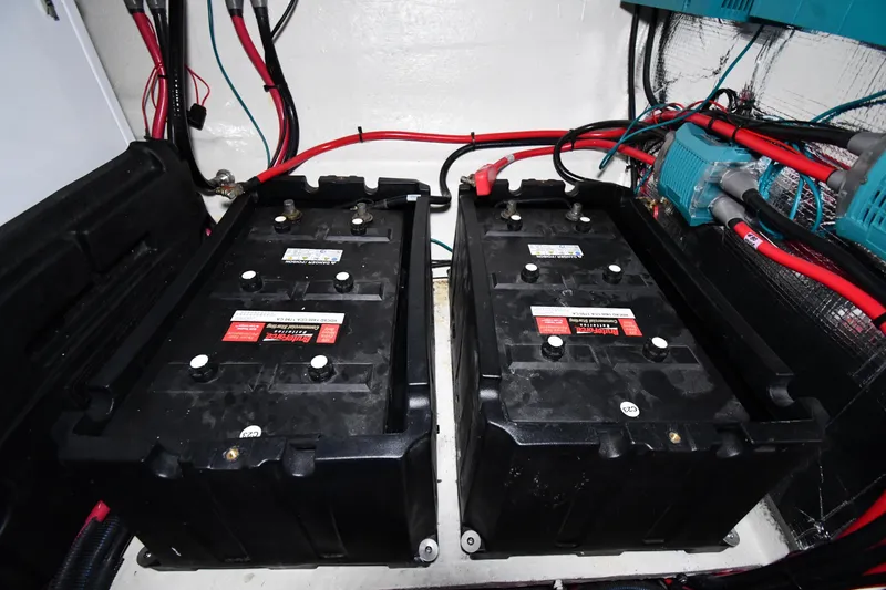 Slide: The Image of Battery compartment of 2024 Regal 42 Fly yacht, featuring dual marine batteries and wiring. - 87