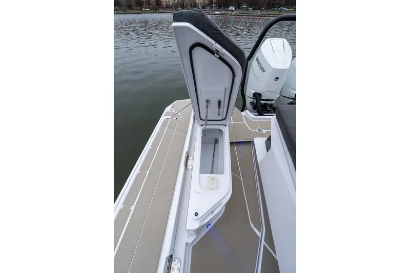Slide: The Image of Open storage compartment on 2027 Axopar 38 Cross Cabin boat, docked by the water. - 20